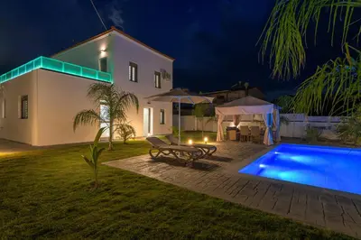 a villa with a swimming pool at night at Villa Costa in Ixia
