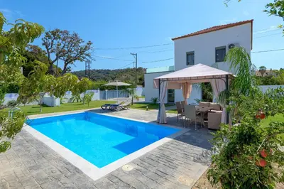 a pool with a gazebo and a house at Villa Costa in Ixia
