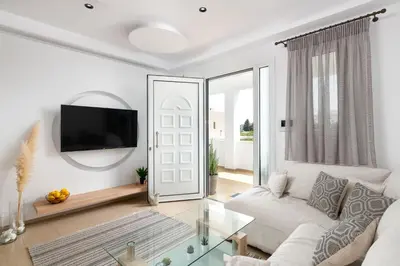 a living room with a white couch and a glass table at White House Kokas Luxury Apartments in Kremasti