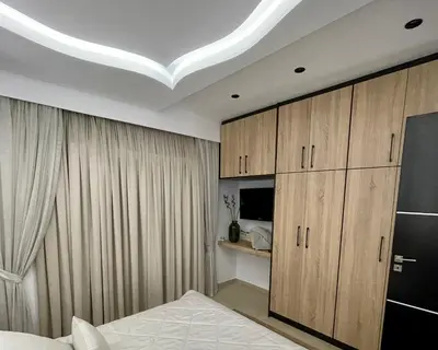 a bedroom with a bed and wooden cabinets at White House Kokas Luxury Apartments in Kremasti