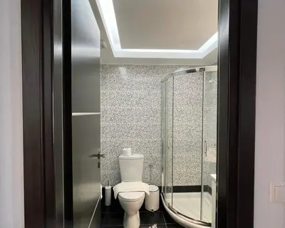 a bathroom with a toilet and a glass shower at White House Kokas Luxury Apartments in Kremasti