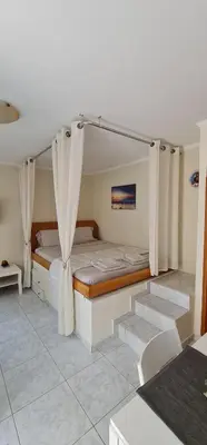 a bedroom with two beds with curtains in it at Maria's Little apartment in Rhodes Town