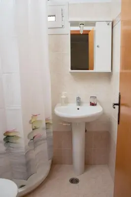 a bathroom with a sink and a shower with a mirror at Maria's Little apartment in Rhodes Town