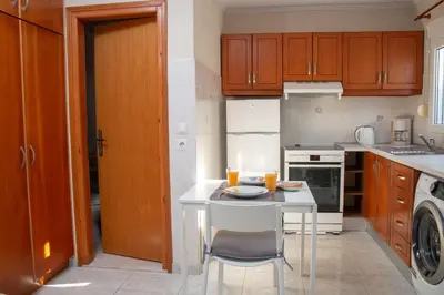 a small kitchen with a white table and a sink at Maria's Little apartment in Rhodes Town