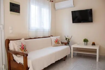 a living room with a couch and a tv at Maria's Little apartment in Rhodes Town