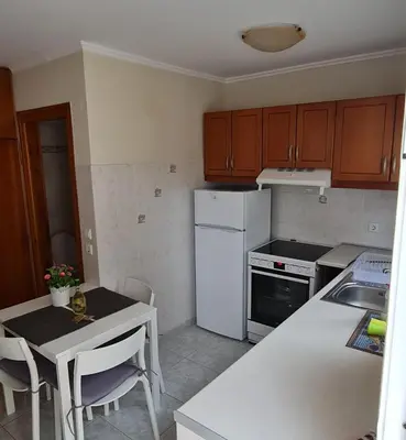a kitchen with a white refrigerator and a table with chairs at Maria's Little apartment in Rhodes Town
