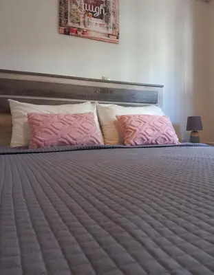 a bedroom with a bed with pink pillows at Family room Rhodes Greece in Ialyssos