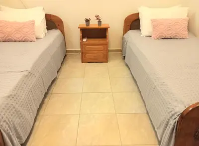two beds in a room with a tiled floor at Family room Rhodes Greece in Ialyssos