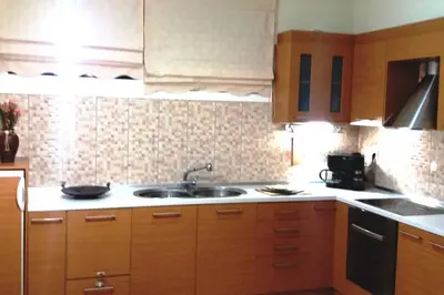a kitchen with wooden cabinets and a sink at Family room Rhodes Greece in Ialyssos