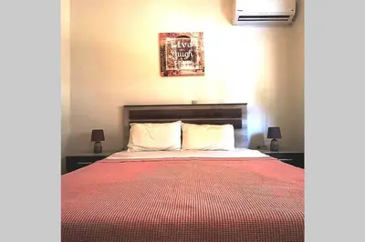 a bedroom with a bed with a red blanket at Family room Rhodes Greece in Ialyssos