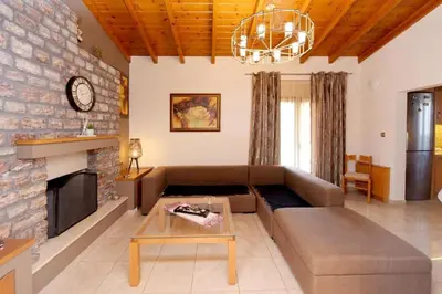 a living room with a couch and a fireplace at Kiparisia Villa in Phanaes