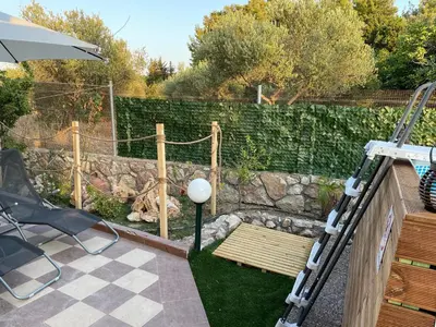 a garden with a wooden bench and a stone wall at Kiparisia Villa in Phanaes