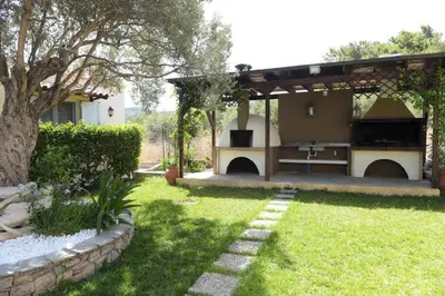 a backyard with an outdoor kitchen with a grill at Kiparisia Villa in Phanaes