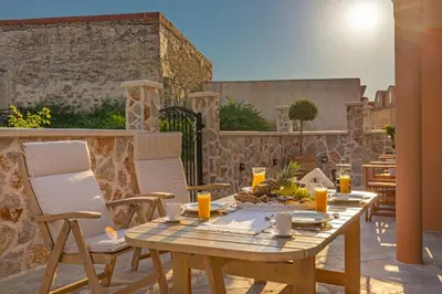 a wooden table and chairs on a patio at Bonseye 2Floor, sea, nature & relax in Kalavárda