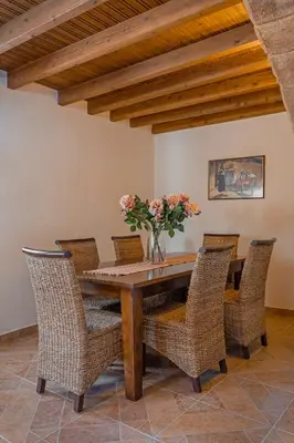 a dining room table with chairs and a vase of flowers at Bonseye 2Floor, sea, nature & relax in Kalavárda
