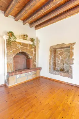 an empty living room with a stone fireplace at Bonseye 2Floor, sea, nature & relax in Kalavárda