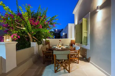 a balcony with a table and chairs and flowers at Villa Theoni in Halki