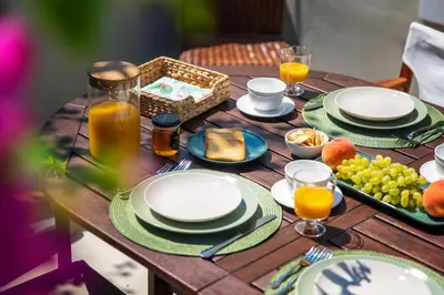 a wooden table topped with plates and glasses of orange juice at Villa Theoni in Halki