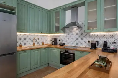 a kitchen with green cabinets and a wooden floor at Villa Theoni in Halki