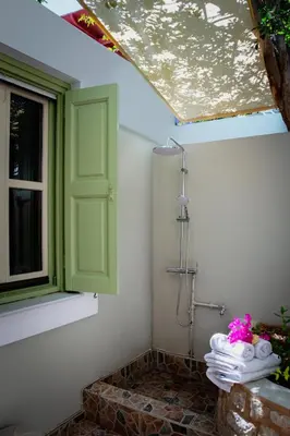 a shower in a bathroom with a window and towels at Villa Theoni in Halki