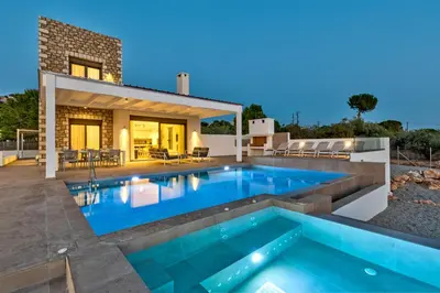 a swimming pool in the backyard of a house at Villa AmberBlue Pefkos in Pefki Rhodes