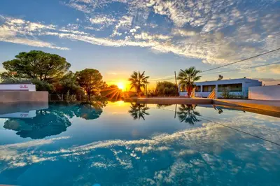 a swimming pool with the sunset in the background at Villa AmberBlue Pefkos in Pefki Rhodes