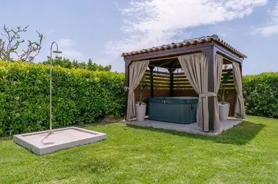 a gazebo in the grass in a yard at Villa Giota Luxury Living with Private Jacuzzi and Free Car in Theologos