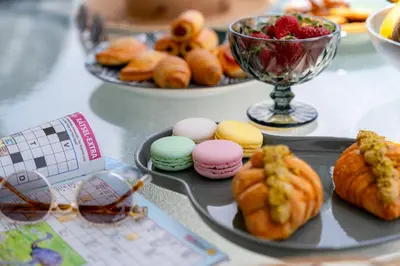 a table with a plate of donuts and a bowl of fruit at Villa Giota Luxury Living with Private Jacuzzi and Free Car in Theologos