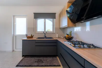 a kitchen with a sink and a stove top oven at Villa Giota Luxury Living with Private Jacuzzi and Free Car in Theologos