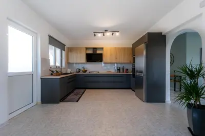 a kitchen with blue cabinets and a large window at Villa Giota Luxury Living with Private Jacuzzi and Free Car in Theologos