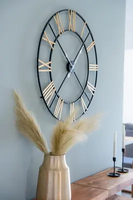 a clock on a wall with feathers in a vase at Villa Giota Luxury Living with Private Jacuzzi and Free Car in Theologos