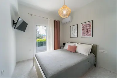 a bedroom with a bed and a tv and a window at Villa Giota Luxury Living with Private Jacuzzi and Free Car in Theologos