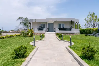 a house with a walkway in front of a yard at Villa Giota Luxury Living with Private Jacuzzi and Free Car in Theologos
