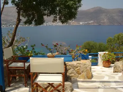 a table and chairs with a view of the water at Antoniadi Rooms in Livadia