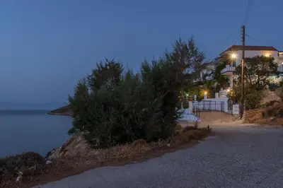 a house with a street light next to the water at Antoniadi Rooms in Livadia