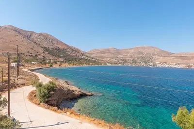 a body of water with mountains in the background at Antoniadi Rooms in Livadia