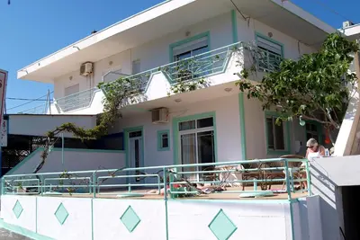 a building with a balcony with a woman on it at Marianthi Studios Stegna in Archangelos