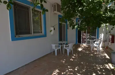 a patio with chairs and a table and a window at Marianthi Studios Stegna in Archangelos