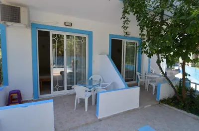 a patio with a table and chairs and a building at Marianthi Studios Stegna in Archangelos