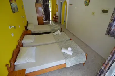 two beds in a room with yellow walls at Marianthi Studios Stegna in Archangelos