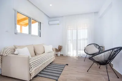 a white living room with a couch and a chair at Rhodian Dunes Villas with Private Pool in Kiotari