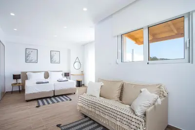 a living room with a couch and a bed at Rhodian Dunes Villas with Private Pool in Kiotari