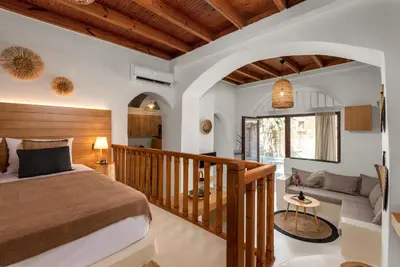 a bedroom with a large bed and a staircase at Voyaz Boutique Apartments & Suites -Old Town in Rhodes Town