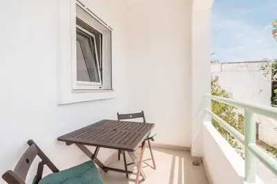a table and chairs on a balcony with a window at CrossRhodes Villas in Pefki Rhodes