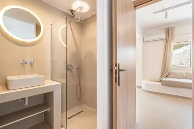 a bathroom with a shower and a sink and a mirror at CrossRhodes Villas in Pefki Rhodes