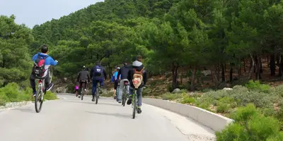 a group of people riding bikes down a road at Thomas Hotel in Monólithos