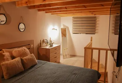 a bedroom with a bed and a staircase with a clock at AFANDOU NANA'S HOUSE in Afantou