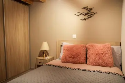 a bedroom with a bed with pink pillows on it at AFANDOU NANA'S HOUSE in Afantou