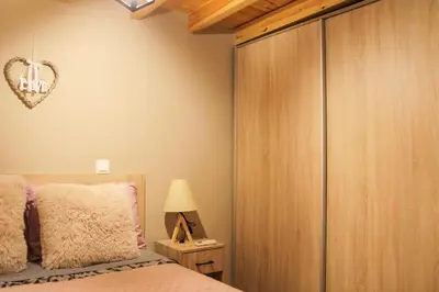 a bedroom with a bed and a large wooden closet at AFANDOU NANA'S HOUSE in Afantou