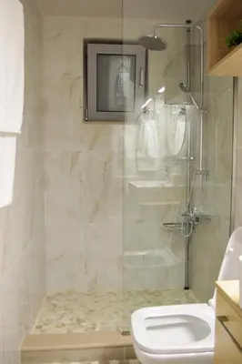 a bathroom with a glass shower with a toilet at AFANDOU NANA'S HOUSE in Afantou